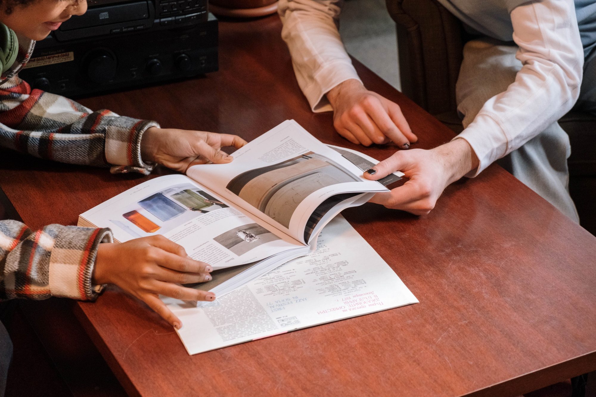 Two people reviewing printed pages together at a desk