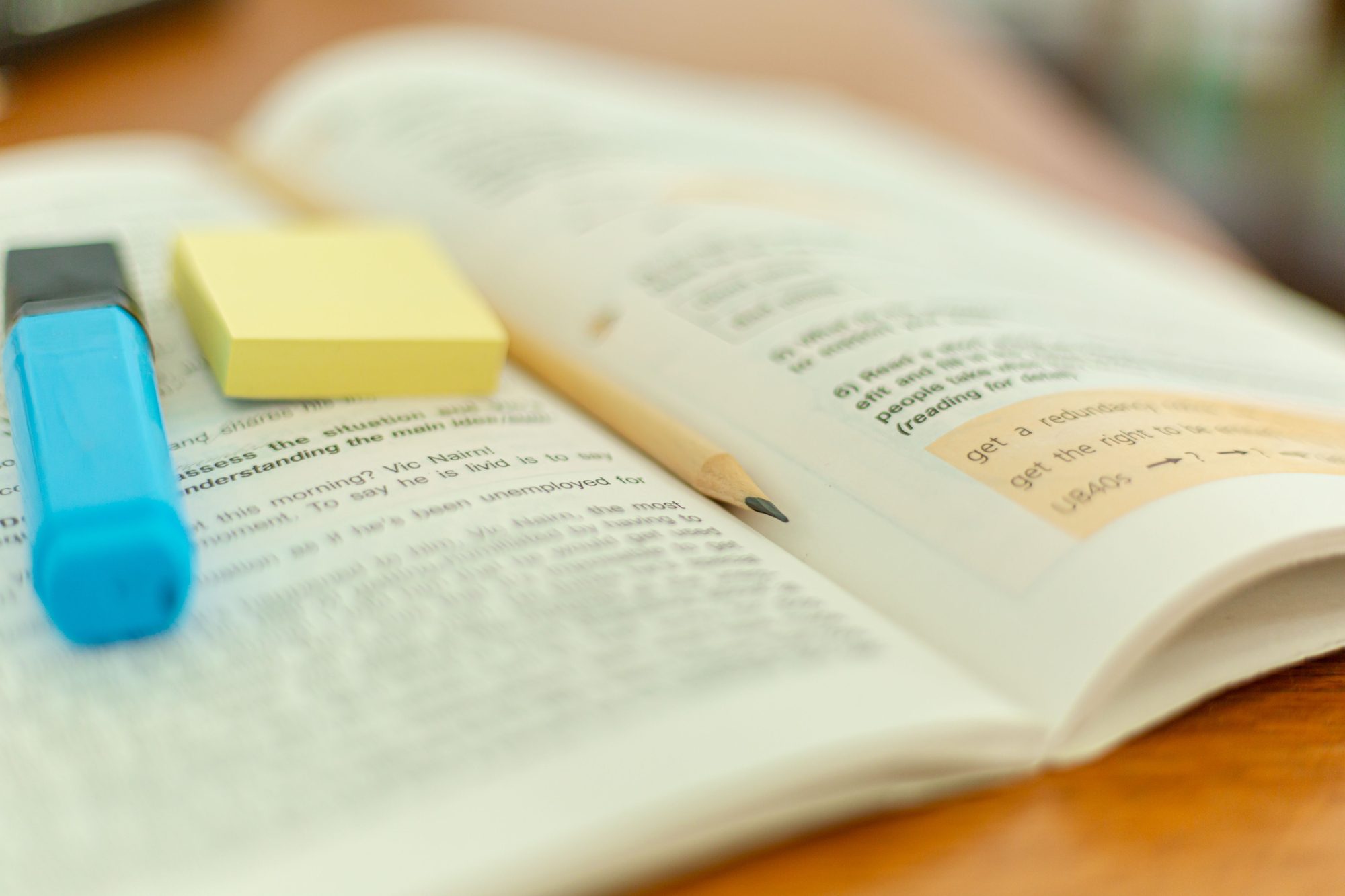 An open book marked up with a highlighter and page tabs